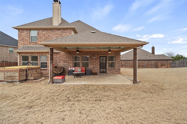 back of property with a hot tub, a patio, and ceiling fan