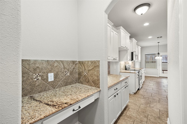 kitchen with stainless steel appliances, tasteful backsplash, light stone countertops, and white cabinets