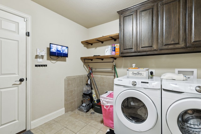 clothes washing area featuring separate washer and dryer, cabinets, a textured ceiling, and light tile patterned flooring