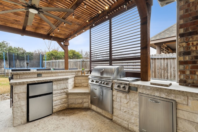 view of patio with a grill, exterior kitchen, and a trampoline