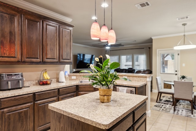 kitchen featuring hanging light fixtures, dark brown cabinetry, ornamental molding, a kitchen island, and kitchen peninsula