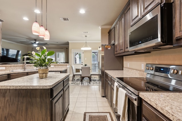 kitchen featuring sink, crown molding, a center island, hanging light fixtures, and appliances with stainless steel finishes