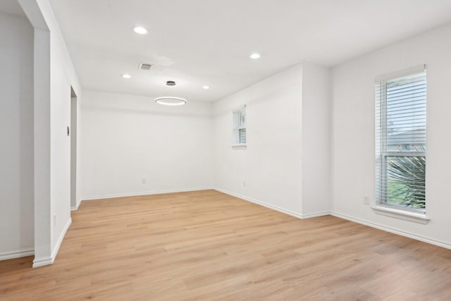 spare room featuring a healthy amount of sunlight and light hardwood / wood-style floors