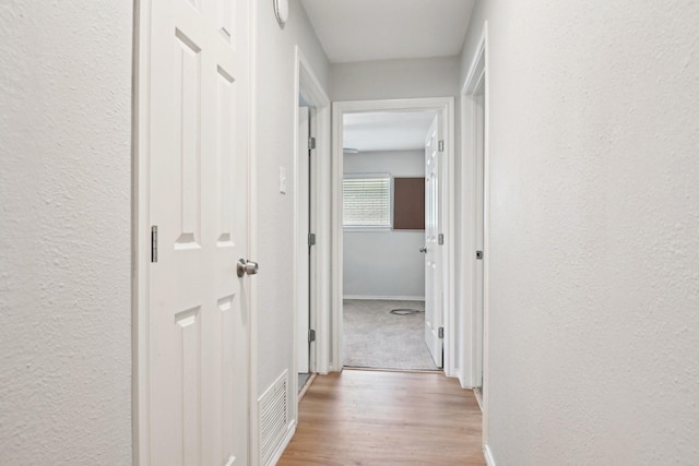 hallway with light hardwood / wood-style floors