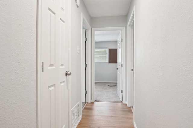 3404 Peachtree Ln, Pantego, TX 76013 - corridor featuring baseboards, light wood-type flooring, and a textured wall