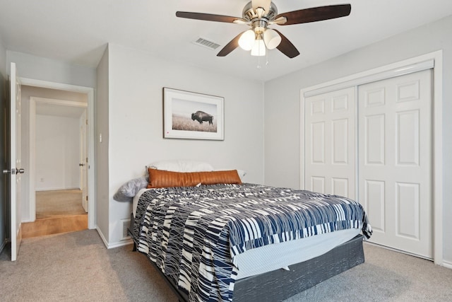 bedroom featuring ceiling fan, light colored carpet, and a closet