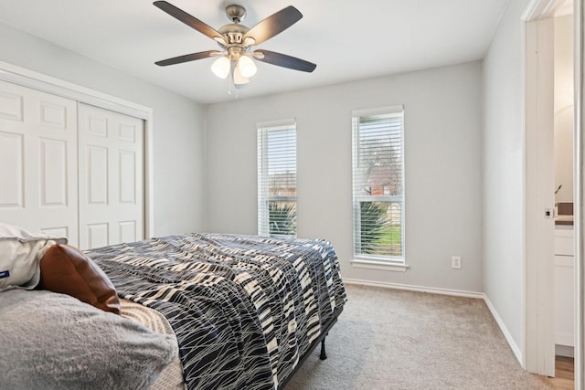 carpeted bedroom with ceiling fan and a closet