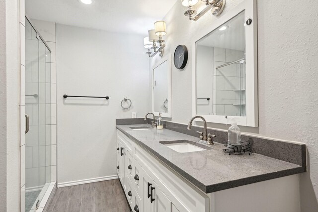 3404 Peachtree Ln, Pantego, TX 76013 - full bathroom featuring wood finished floors, a shower stall, double vanity, and recessed lighting
