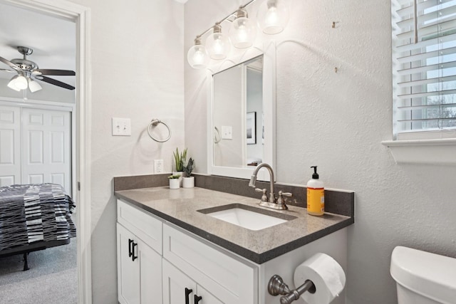 bathroom featuring vanity, toilet, and ceiling fan