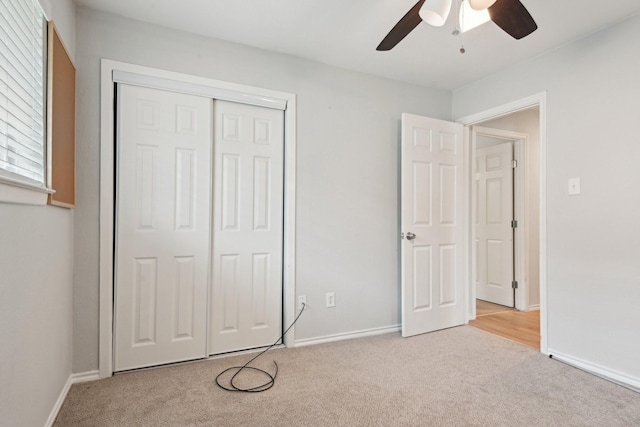 unfurnished bedroom with light colored carpet, ceiling fan, and a closet