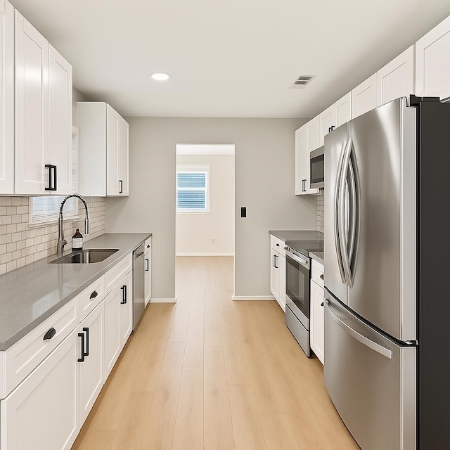 3404 Peachtree Ln, Pantego, TX 76013 - kitchen with appliances with stainless steel finishes, a sink, decorative backsplash, white cabinetry, and baseboards