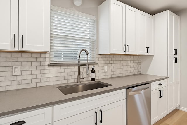 3404 Peachtree Ln, Pantego, TX 76013 - kitchen featuring stainless steel dishwasher, a sink, white cabinetry, and backsplash