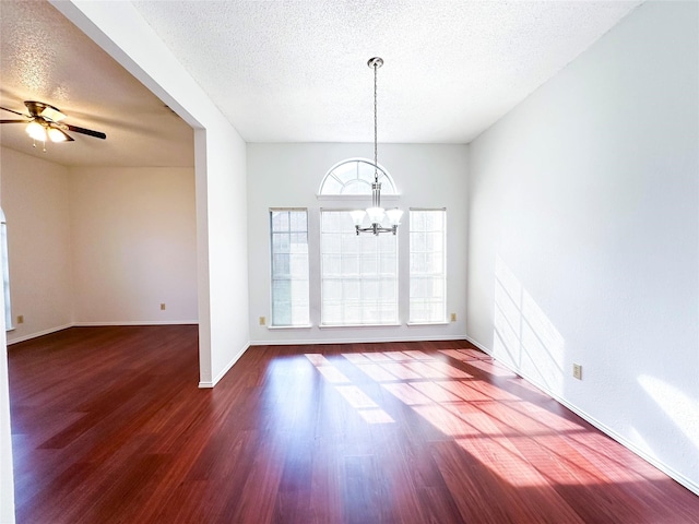 empty room featuring dark hardwood / wood-style flooring, ceiling fan with notable chandelier, and a textured ceiling