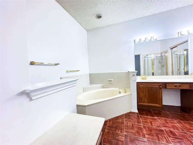 bathroom with shower with separate bathtub, vanity, and a textured ceiling