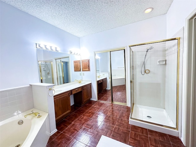 bathroom with plus walk in shower, parquet floors, vanity, and a textured ceiling