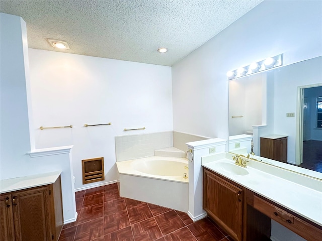 bathroom with vanity, parquet floors, a textured ceiling, and a bathtub