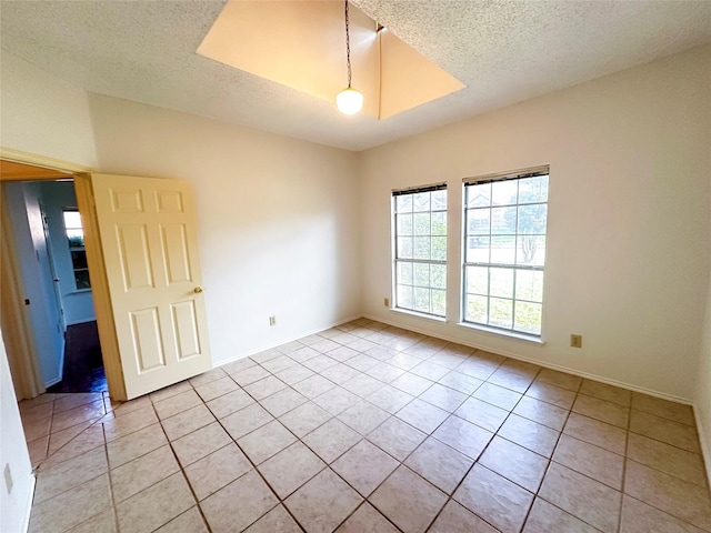 tiled spare room with a textured ceiling