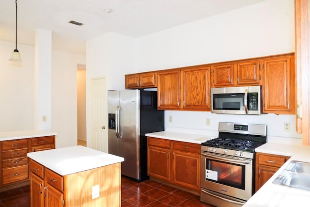 kitchen with stainless steel appliances, decorative light fixtures, and a kitchen island