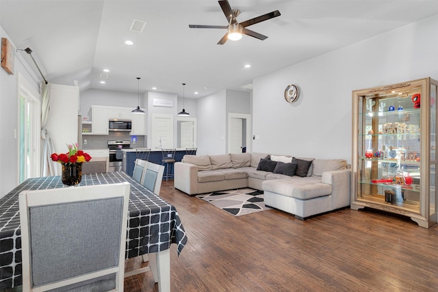 living room featuring vaulted ceiling, dark hardwood / wood-style floors, and ceiling fan