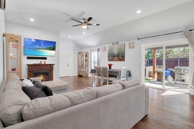 living room with hardwood / wood-style flooring, ceiling fan, and lofted ceiling