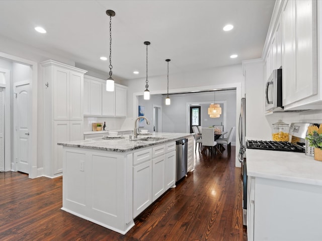 kitchen featuring sink, white cabinetry, a center island with sink, pendant lighting, and stainless steel appliances