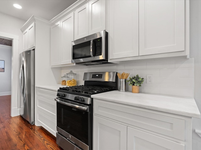 kitchen featuring tasteful backsplash, appliances with stainless steel finishes, dark hardwood / wood-style flooring, and white cabinets