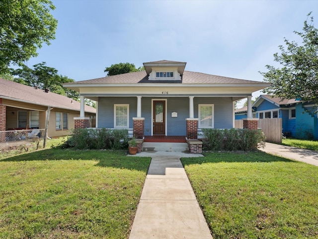 bungalow-style home with covered porch and a front lawn