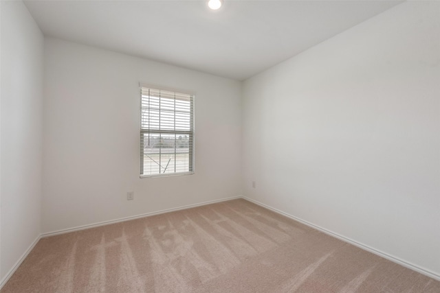 unfurnished room featuring light carpet