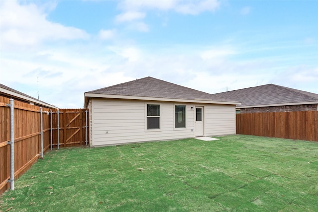 rear view of property with a yard