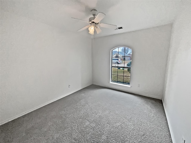 carpeted spare room with ceiling fan