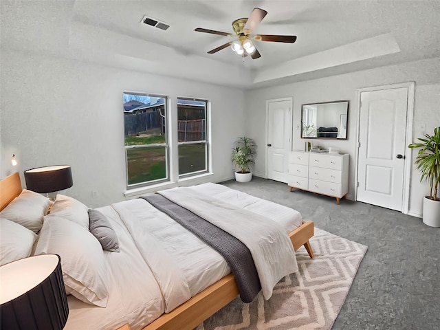 bedroom featuring ceiling fan and a tray ceiling