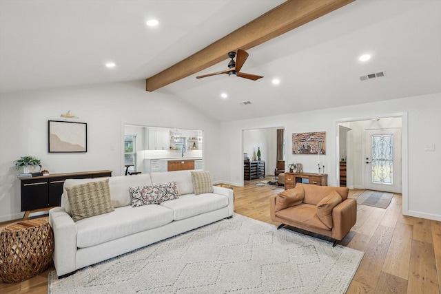 living room with ceiling fan, lofted ceiling with beams, and light hardwood / wood-style flooring