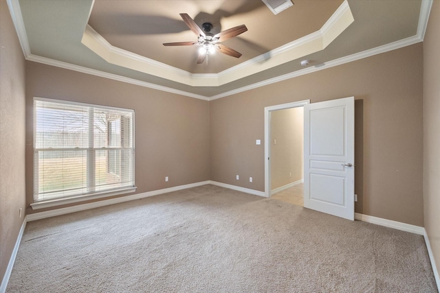 carpeted empty room with baseboards, a raised ceiling, ornamental molding, and a ceiling fan