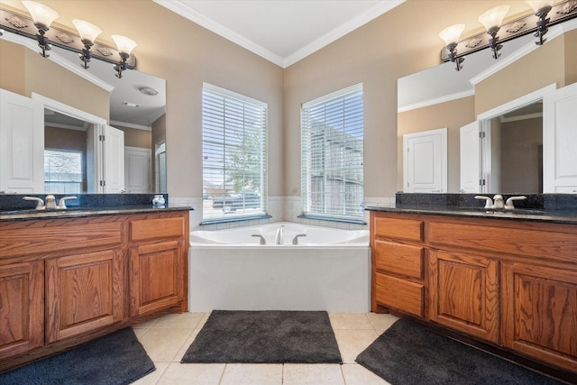 full bathroom featuring tile patterned floors, a garden tub, two vanities, ornamental molding, and a sink