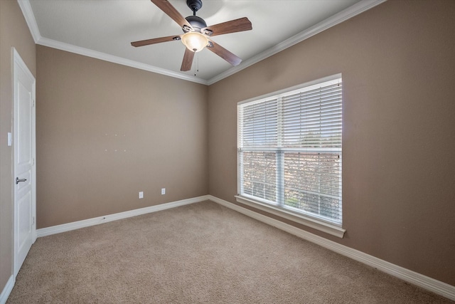 spare room with a ceiling fan, carpet, baseboards, and ornamental molding