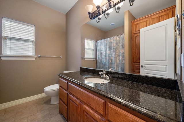 bathroom featuring tile patterned flooring, curtained shower, baseboards, toilet, and vanity