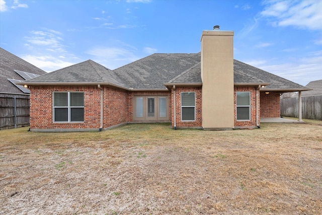 back of house with a lawn and a patio area