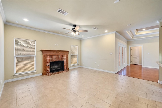 unfurnished living room featuring visible vents, crown molding, baseboards, a fireplace, and a ceiling fan