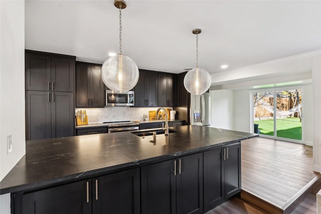 kitchen featuring sink, tasteful backsplash, decorative light fixtures, appliances with stainless steel finishes, and dark hardwood / wood-style floors