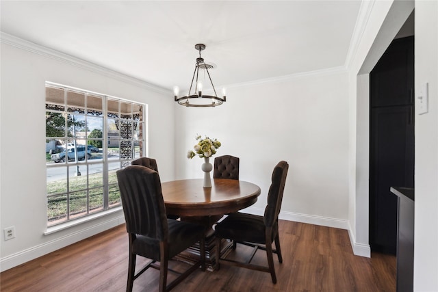 dining space featuring dark wood-type flooring, ornamental molding, and a chandelier