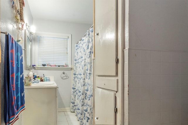 bathroom with tile patterned flooring, tile walls, curtained shower, and vanity