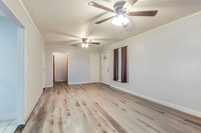 spare room featuring baseboards, light wood-type flooring, a ceiling fan, and ornamental molding