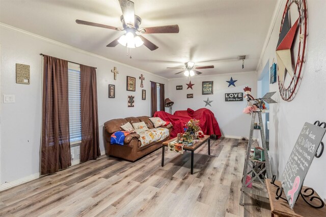 living area with baseboards, light wood-style floors, ceiling fan, and crown molding