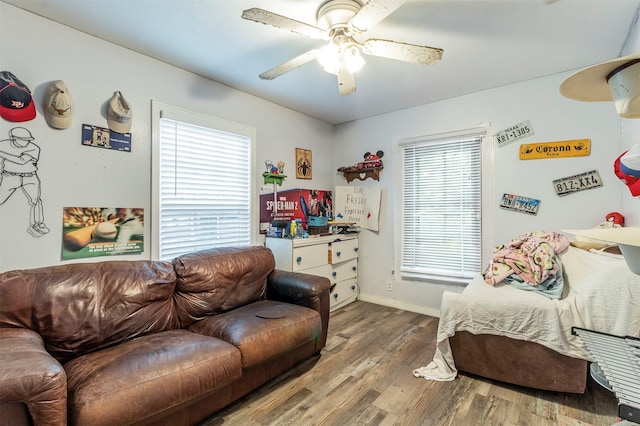 interior space with baseboards, ceiling fan, and wood finished floors