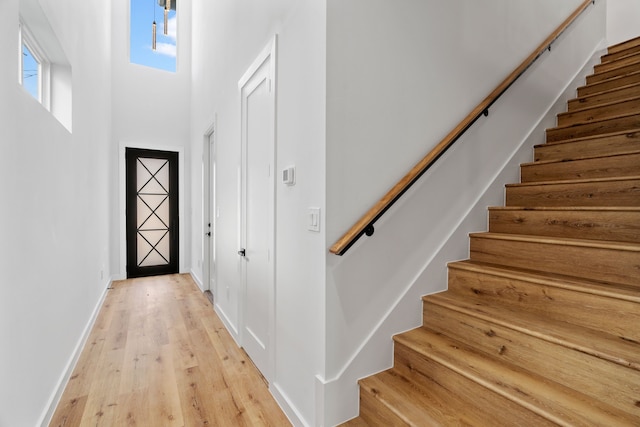 entrance foyer with a towering ceiling and light hardwood / wood-style floors