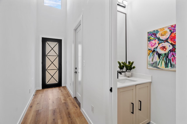 hallway featuring sink and light hardwood / wood-style flooring