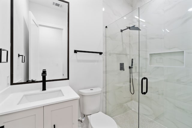 bathroom featuring vanity, toilet, and an enclosed shower