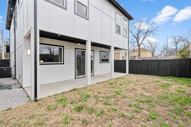 back of property with a lawn and a patio