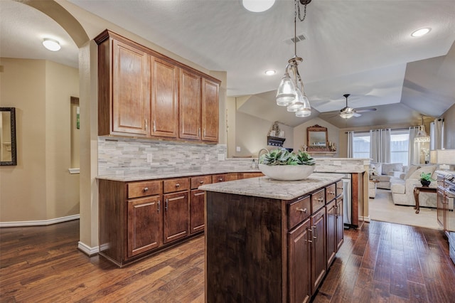 kitchen featuring tasteful backsplash, lofted ceiling, a center island, and dark wood-type flooring