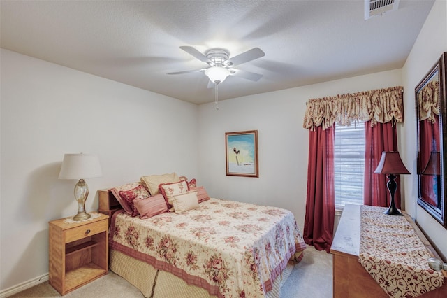 carpeted bedroom featuring a textured ceiling and ceiling fan